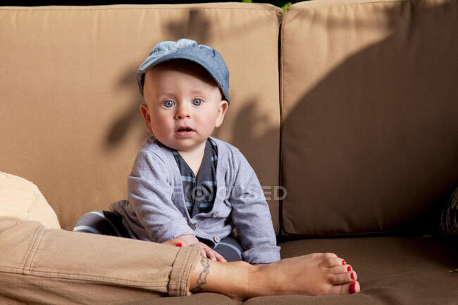 Baby on sofa with parent — Stock Photo