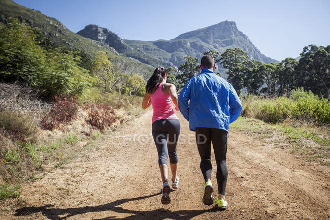 Young couple jogging in forest — Stock Photo