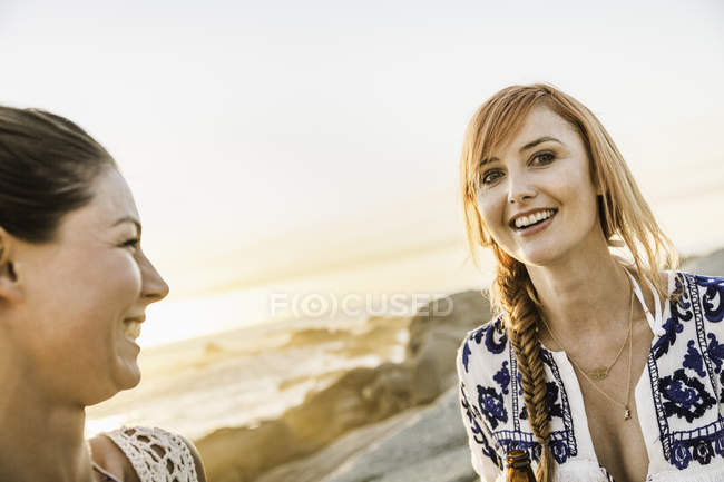 Portrait of two mid adult female friends on beach at sunset, Cape Town, South Africa — Stock Photo