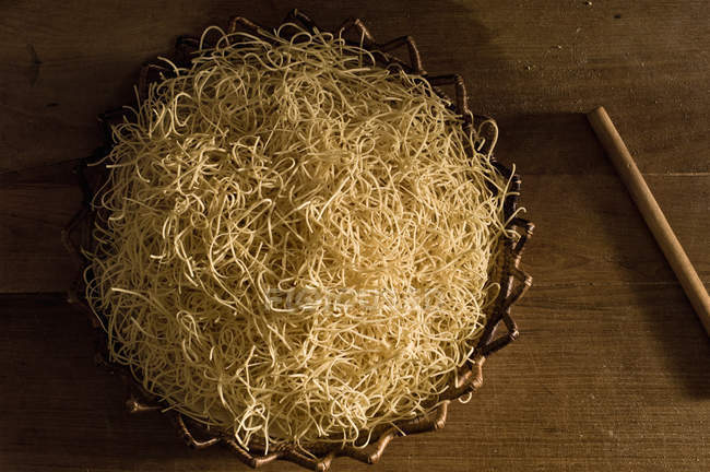 Panier de pâte à pâtes dans un bol sur la table — Photo de stock