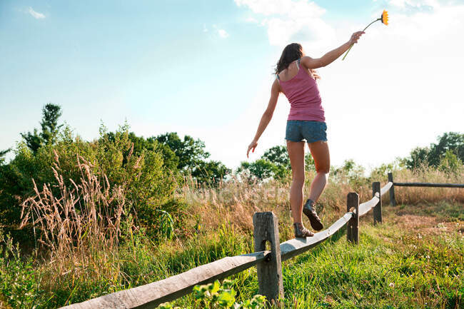 Adolescente équilibrage sur la clôture en bois — Photo de stock