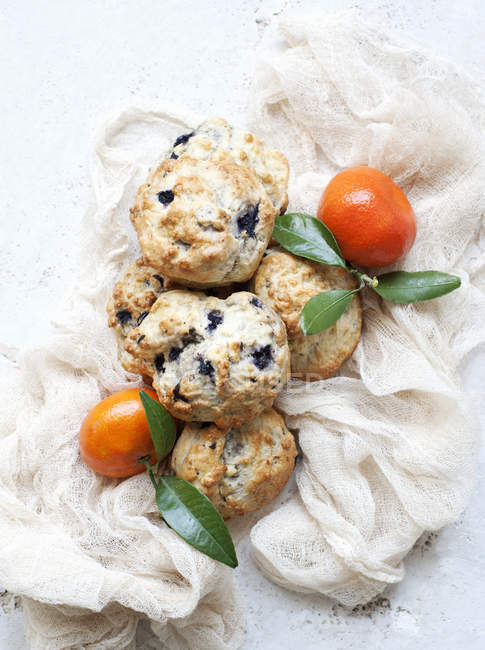 Still life of blueberry scones with tangerines — Stock Photo