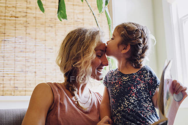 Female toddler kissing mother on forehead — Stock Photo
