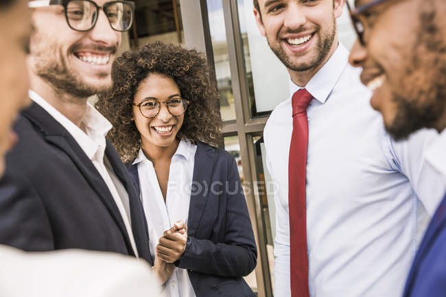 Empresarios y empresarias hablando fuera de la oficina - foto de stock