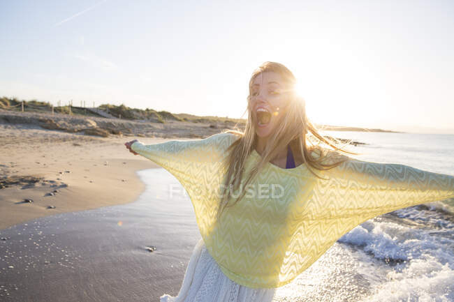 Молодая женщина на пляже, танцует, улыбается — стоковое фото