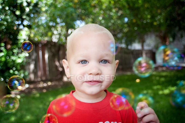 Retrato de menino com bolhas olhando para a câmera — Fotografia de Stock