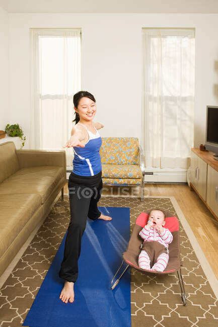 Une mère pratiquant le yoga — Photo de stock