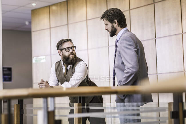 Dos hombres de negocios hablando en la oficina balcón - foto de stock