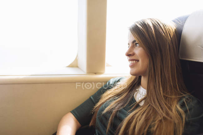 Young female tourist gazing out of train carriage window, Macau, Hong Kong, China — Stock Photo