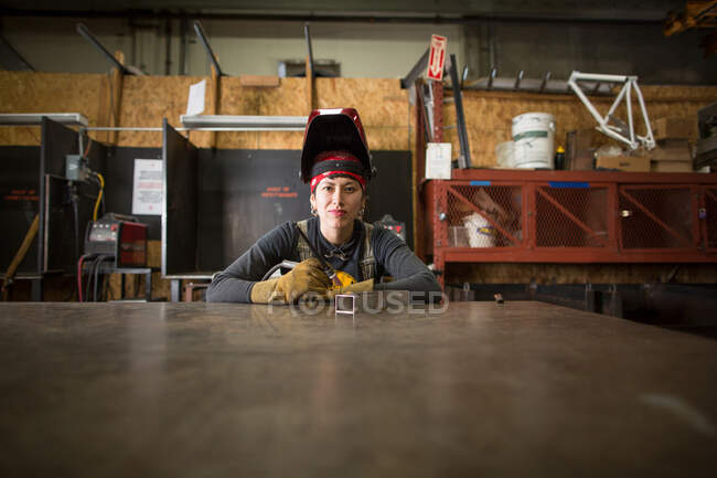 Портрет женщины-металлиста на стенде мастерской — стоковое фото
