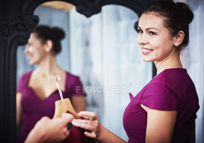 Jeune femme essayant sur robe — Photo de stock