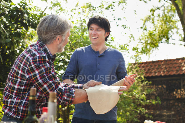Pai e filho adulto fazendo massa de pizza — Fotografia de Stock