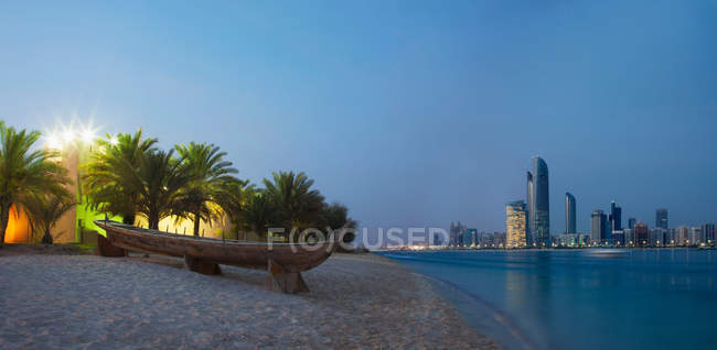 Canoe on sand at urban beach with buildings view of background — Stock Photo