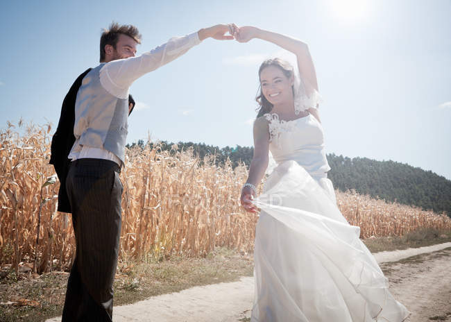 Newlywed couple dancing outdoors — Stock Photo