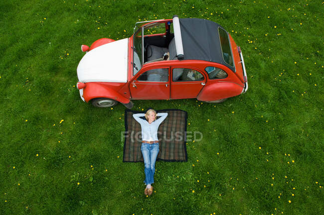 Overhead view of mature woman relaxing on picnic blanket — Stock Photo