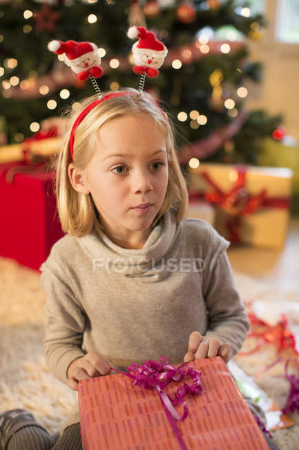 Mädchen hält Weihnachtsgeschenk zu Hause — Stockfoto
