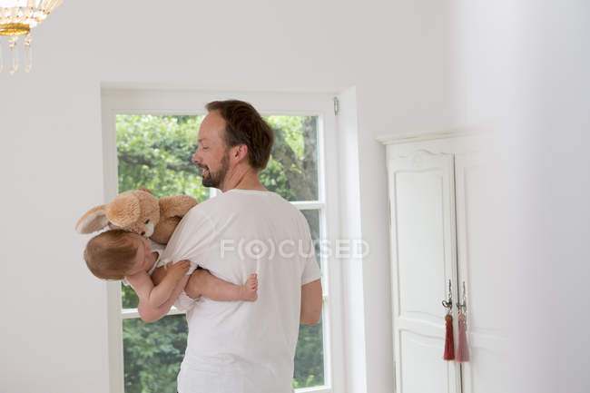 Father holding baby daughter in arms — Stock Photo