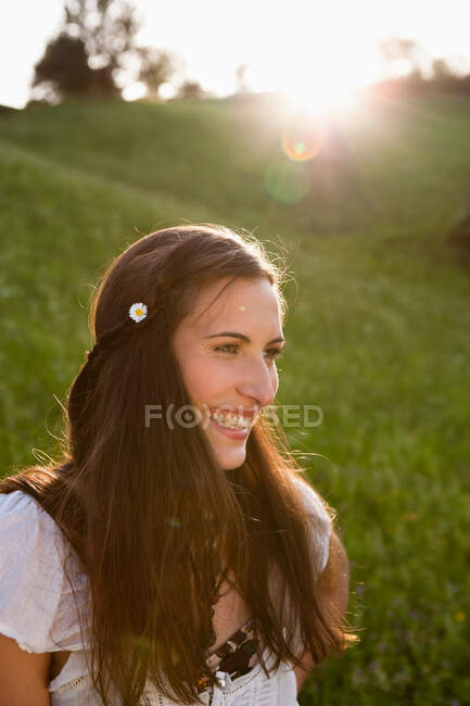 Mujer sonriente vistiendo flor en su cabello - foto de stock