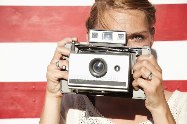 Woman taking photograph using vintage camera — Stock Photo