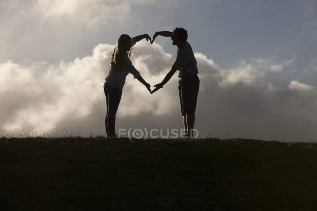 Couple forming heart shape with hands — Stock Photo