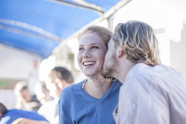 Cape Town, South Africa, young male kisses his partner on the cheek while onboard the yatch — Stock Photo