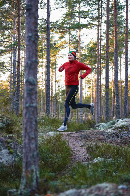 Mujer corriendo en el bosque, enfoque selectivo - foto de stock