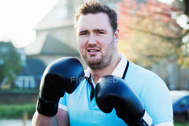 Boxeador sosteniendo guantes al aire libre - foto de stock