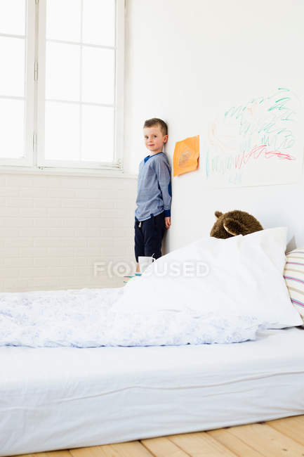 Boy with drawings on bedroom wall — Stock Photo