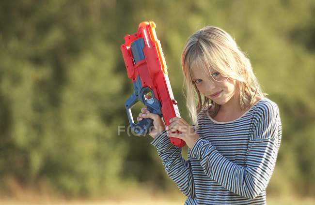 Portrait of girl holding water gun, Buonconvento, Tuscany, Italy — Stock Photo