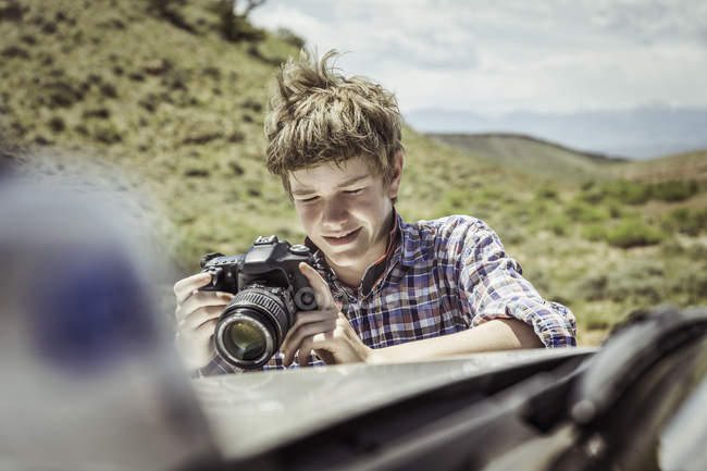 Підлітком перегляд цифрових Дзеркальних на off road транспортного засобу капот, Bridger, штат Монтана, США — стокове фото