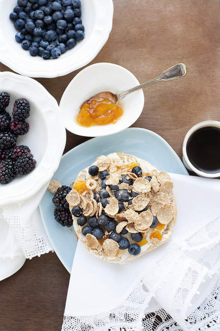 Top view of muesli with blueberries and blackberries on wooden table in kitchen — Stock Photo