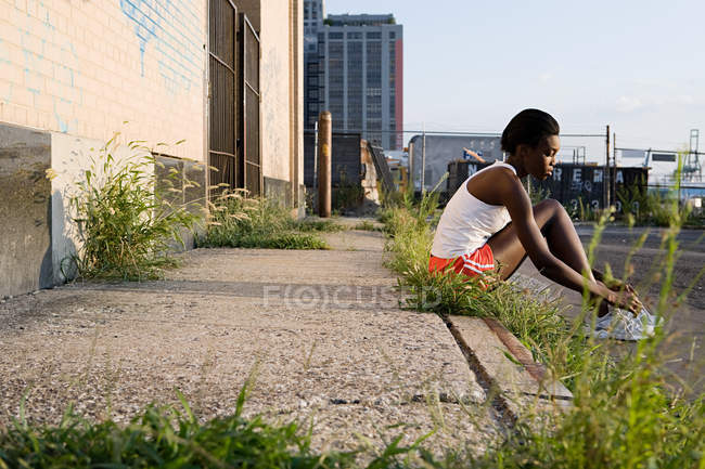 Läufer sitzt auf Gehweg — Stockfoto
