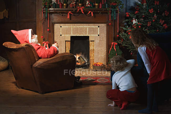 Enfants regardant Santa Claus dans le salon — Photo de stock