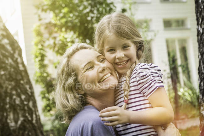 Grandmother and granddaughter hugging outdoors together — Stock Photo