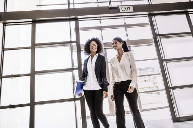 Two young businesswomen arriving at office entrance — Stock Photo