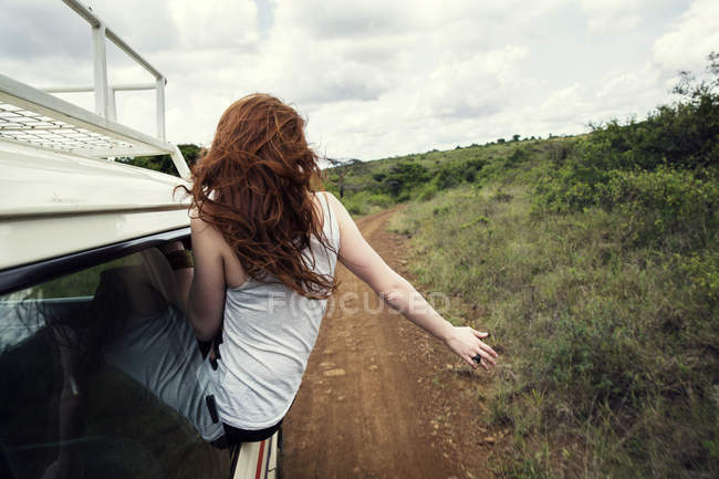 Mulher sentada na porta do veículo no parque da vida selvagem, Nairobi, Quênia — Fotografia de Stock