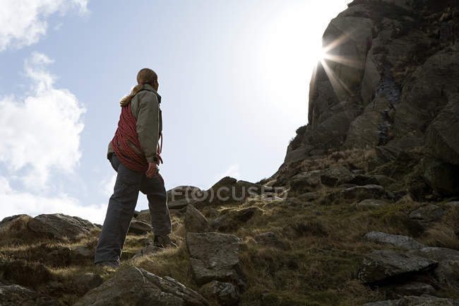 Junge Frau blickt zu Felsen auf — Stockfoto