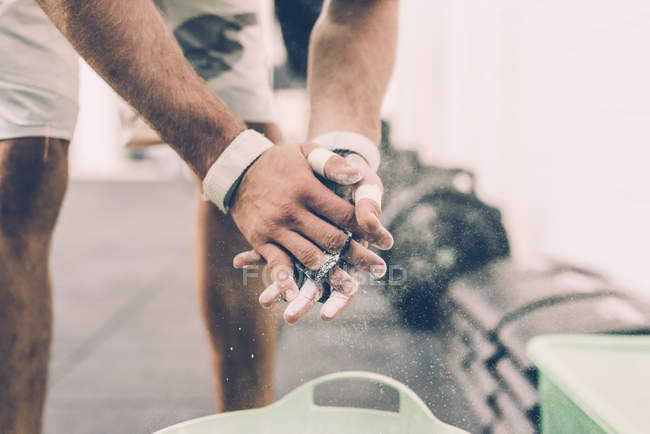 Schnappschuss eines männlichen Crosstrainers mit Kreidehandschuhen in Turnhalle — Stockfoto