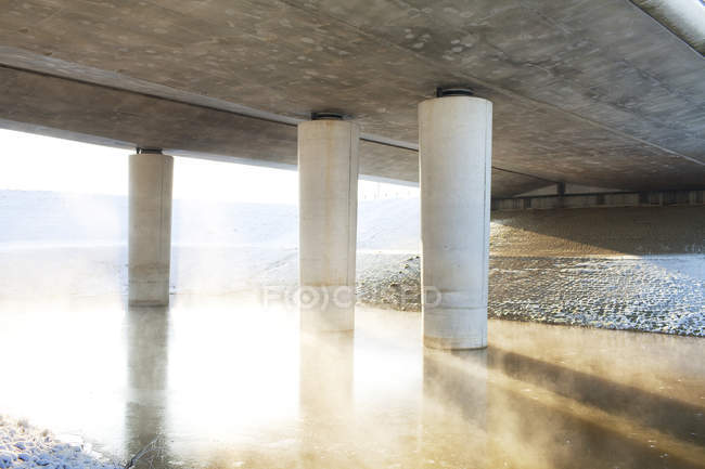 Puente sobre el río brumoso - foto de stock