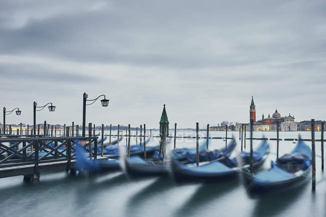 Góndolas borrosas y vista lejana de la Iglesia de San Giorgio Maggiore, Venecia, Italia - foto de stock