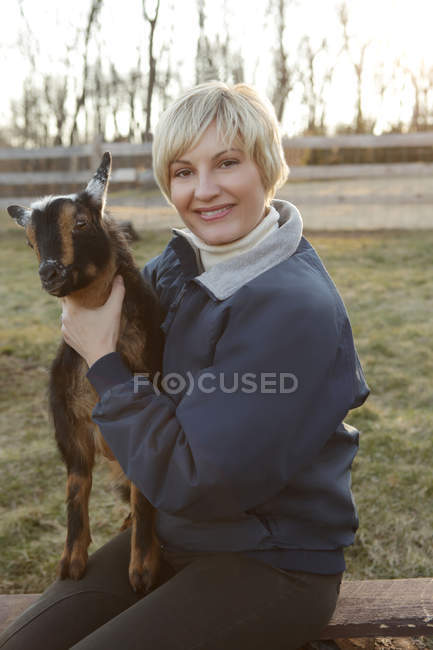 Портрет женщины среднего возраста, держащей козу — стоковое фото