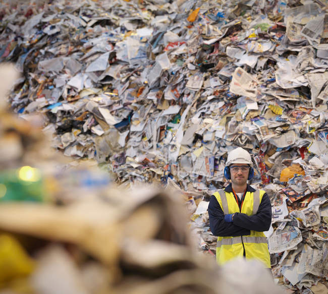 Trabajador con papel en planta de reciclaje - foto de stock