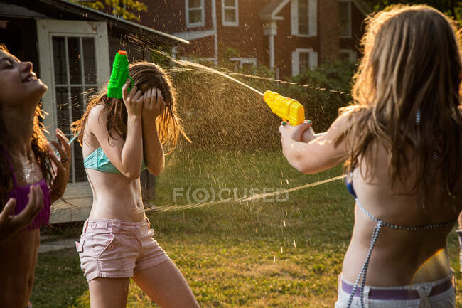 Девушки дерутся на воде с водяными пистолетами — стоковое фото