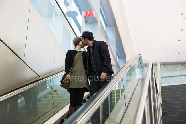 Пара поцелуев на эскалаторе на улице — стоковое фото