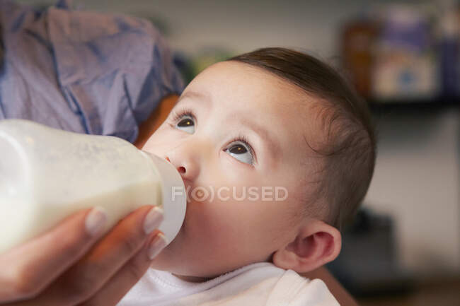 Bebé niña bebiendo botella de leche - foto de stock
