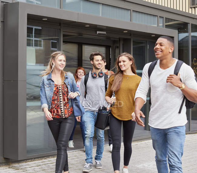 Group of male and female students leaving higher education college — Stock Photo