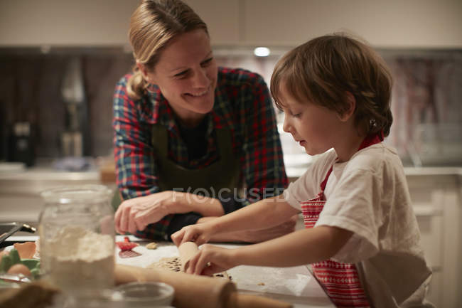 Donna matura e figlio rotolamento pasta sul bancone della cucina — Foto stock