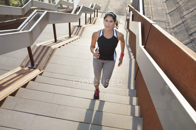 Бегущая по городской лестнице бегущая женщина — стоковое фото
