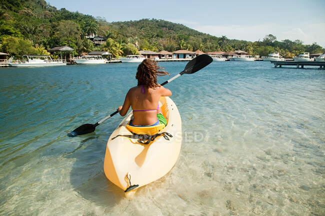 Mujer joven kayak en el mar - foto de stock