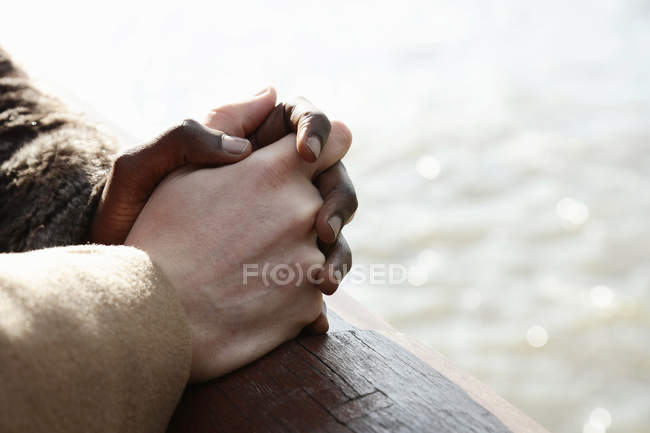 Multi ethnic couple outdoors, holding hands, close-up — Stock Photo